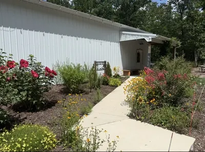 Exterior of the event building with a planted border and concrete path running alongside