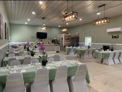 Wide interior of the event building laid out with round and trestle tables for a seated event