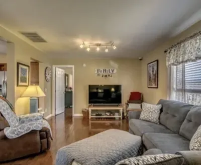 Residential living room with track lighting, sofas and an adjoining hallway